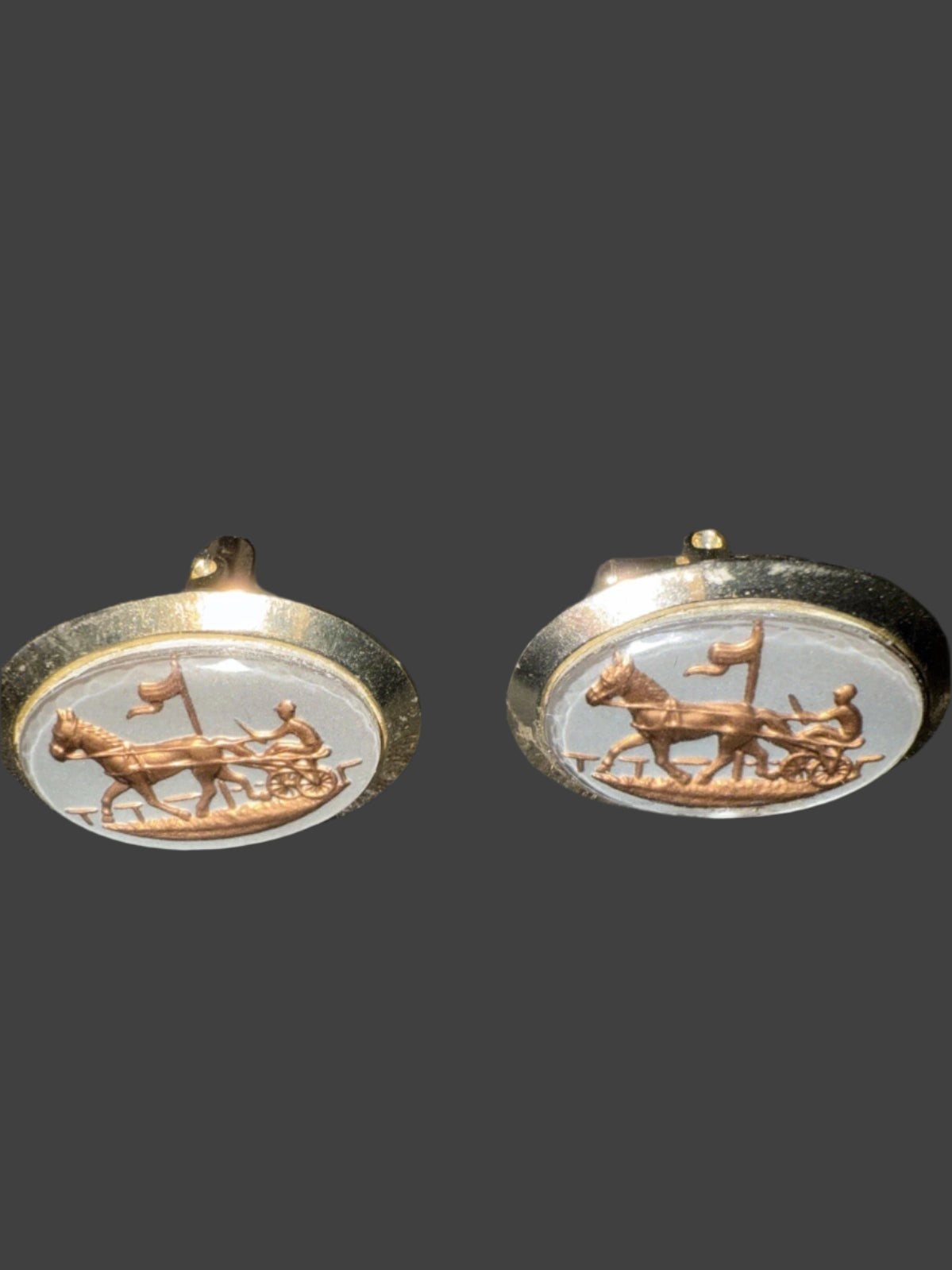 Pair of cufflinks with a design on a dark textured background