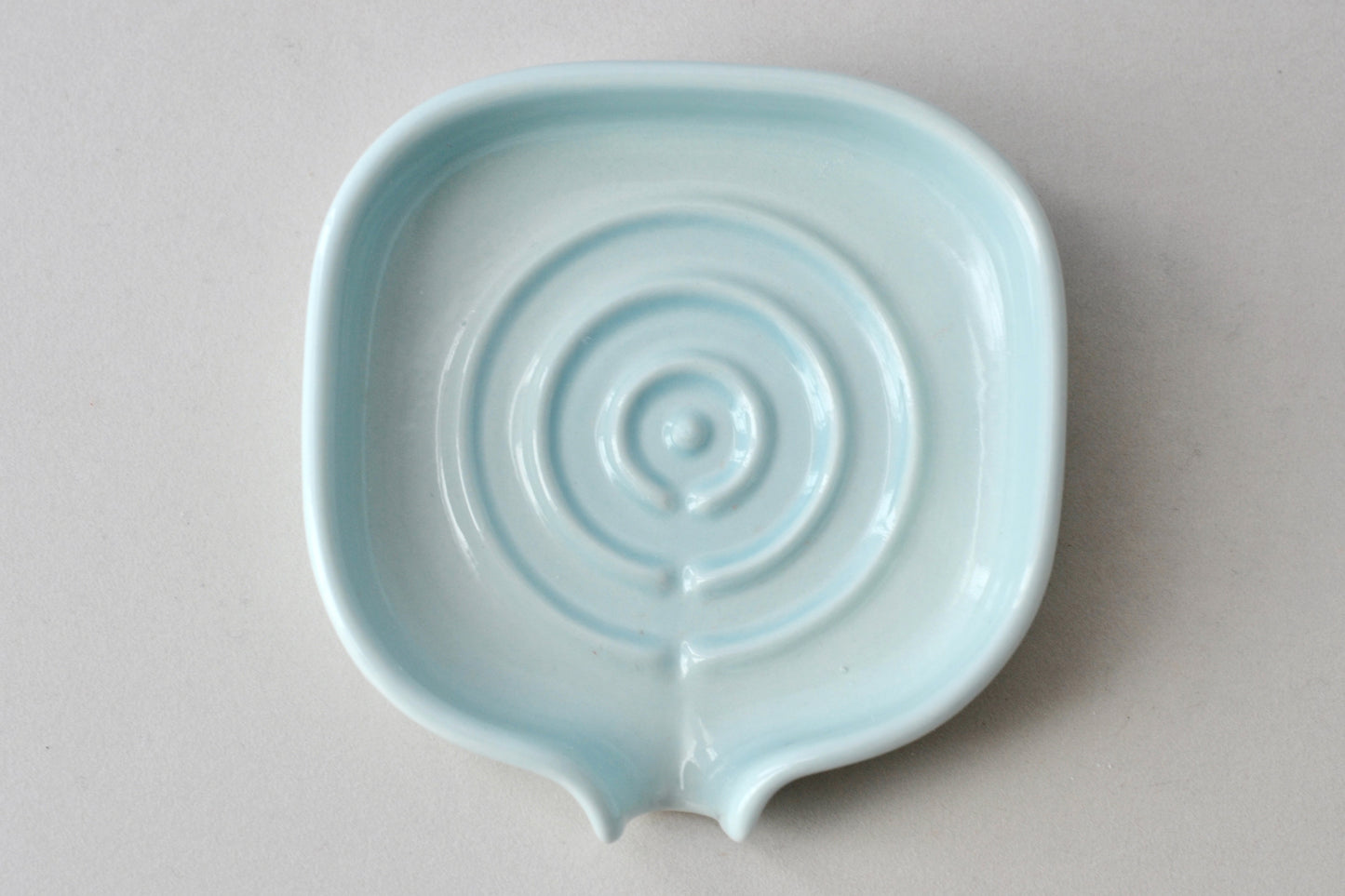 Elegant soft celery color self-draining porcelain soap dish with a sloped design to keep soap dry and clean. Pattern shown. Soap not include