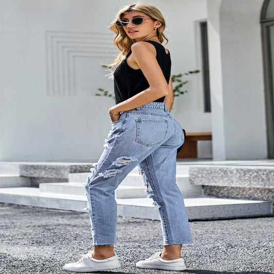 Woman wearing light blue jeans and a black top outdoors.