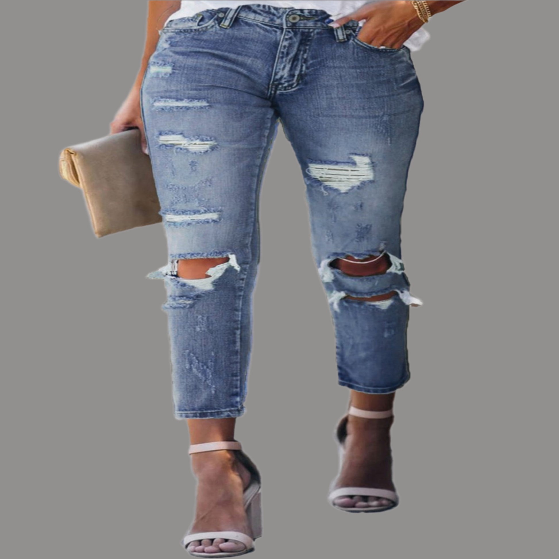 Ripped blue jeans worn by a person on a white background