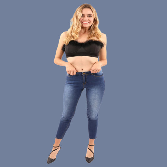 Woman wearing a black crop top and blue jeans on a white background
