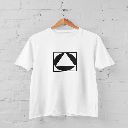 White t-shirt with a black geometric design on a hanger against a white brick wall.